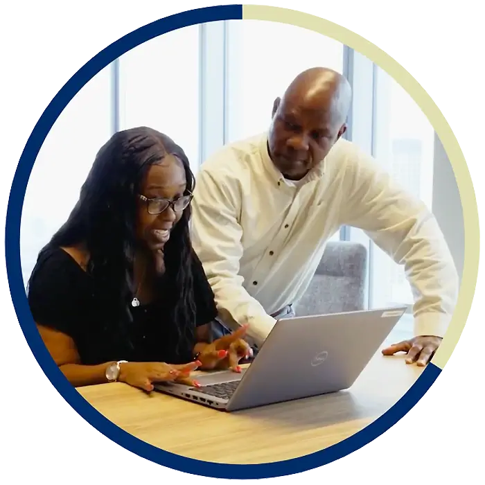 Two NFA employees looking at a laptop.