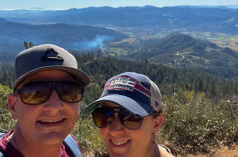 Two hikers smiling with Napa Valley region in the background