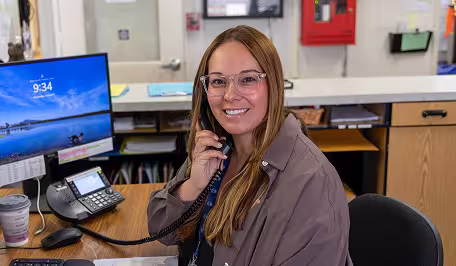 NVUSD employee sitting at her desk, smiling.