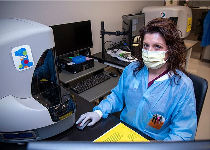 Valarie Burns, a Medical Laboratory Technician, working at a desk in the lab.
