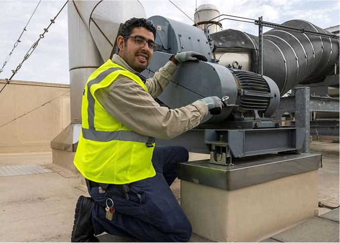 A member of the Building Systems facilities team working on a rooftop HVAC.