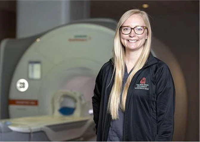 MRI Technologist Jessica standing in front of an MRI scanner.