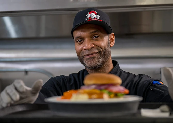 A member of the nutrition services team making food in a kitchen.