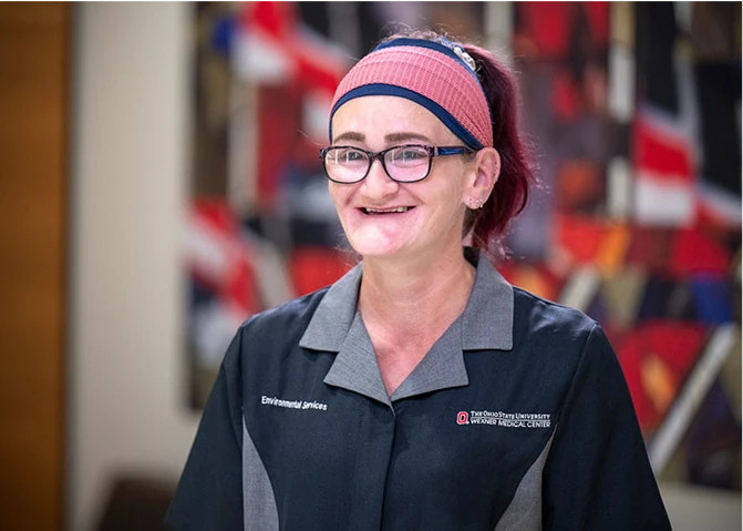 A smiling environmental services staff member.