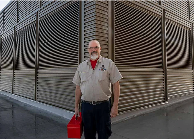 A maintenance employee carrying a toolbox.