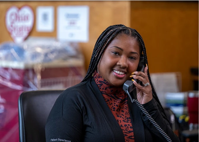 A patient experience employee talking on the phone in the office.