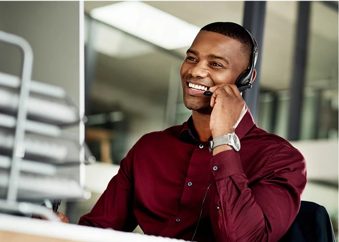 A smiling administrative employee talking into a headset.