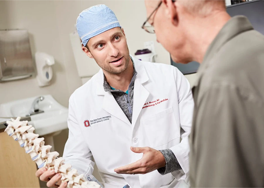 An anesthesiology and pain medicine doctor talking to a patient about the spine.