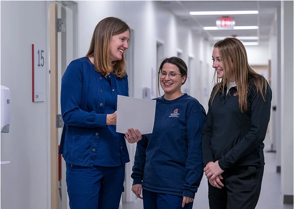 A group of nurses talking in a hallway.
