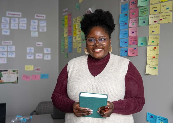 A happy Supply Chain team member standing in an office.