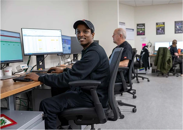 A Supply Chain team member using a computer in an office.