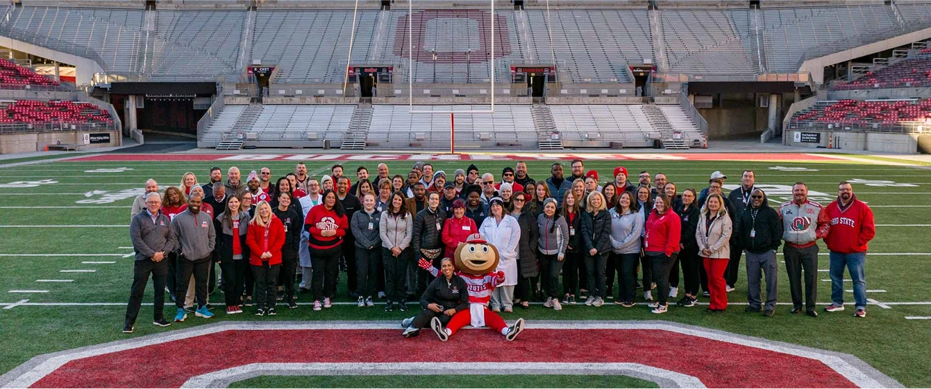 Supply Chain team members on the football field posing for a group photo.