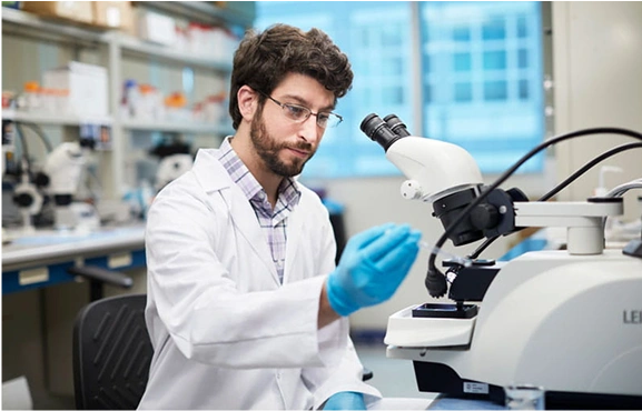 An OSU Medical Center researcher using a microscope.
