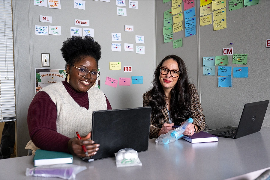 Two smiling employees working together in an office.