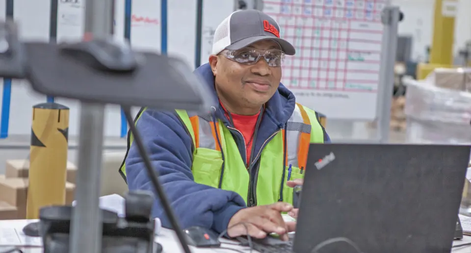 An Oatey distribution employee working on a laptop.