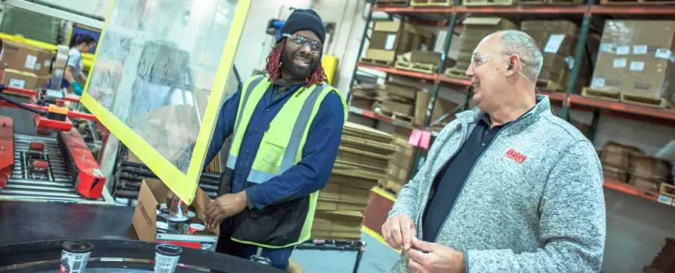 Oatey manufacturing employees working and laughing together.