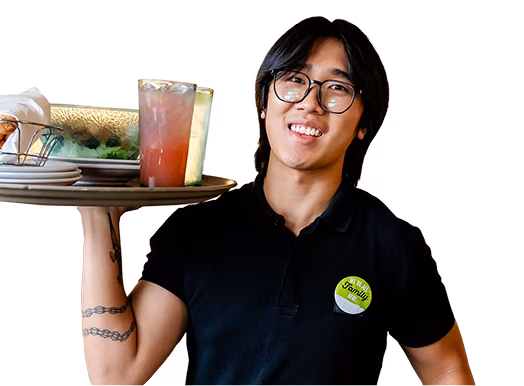 An Olive Garden team member smiling and holding a tray.