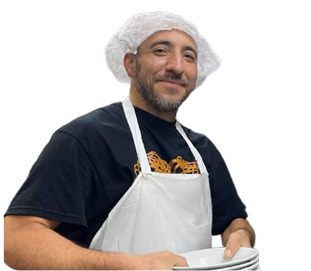 An Olive Garden dishwasher holding a stack of plates and smiling.