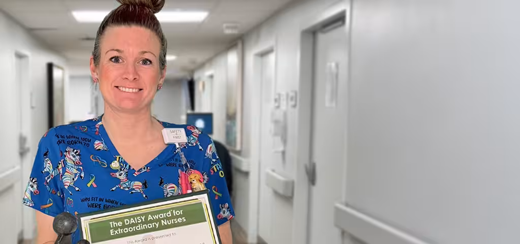 Phoebe nurse holding a Daisy Award certificate for nursing excellences