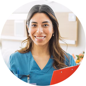 Smiling nurse in blue scrubs holding a clipboard