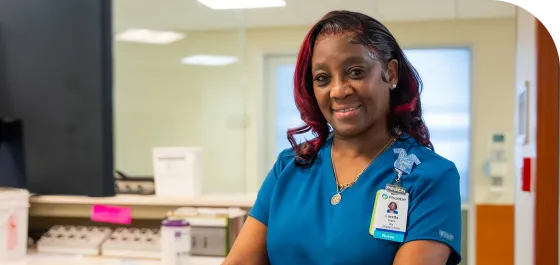 A nurse standing and smiling.