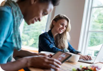 Women smiling while working on computers.