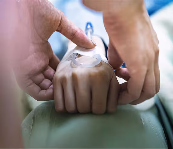 A nurse caring for a patient's hand.