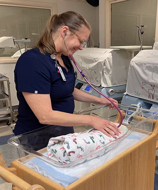 A Parrish nurse caring for a newborn in the nursery.