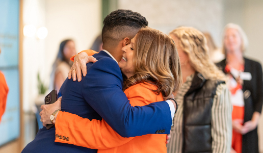 Two PatientPoint employees smiling and hugging.