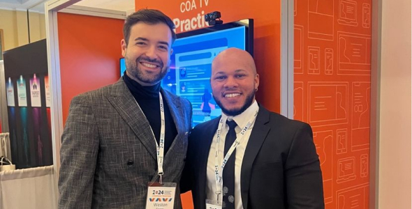 Two PatientPoint employees standing and smiling at a conference.