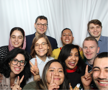 A group of PatientPoint employees making silly faces inside a photo booth.