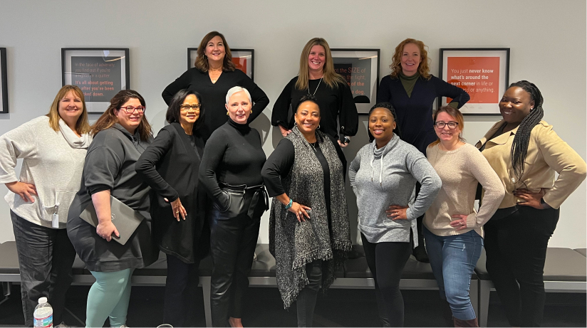 A group of women professionals standing together and smiling.