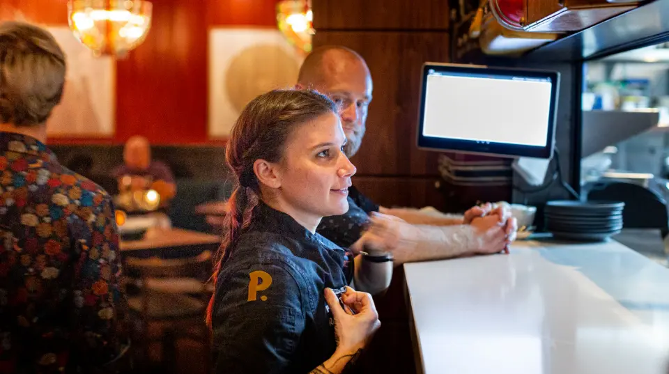  	Postino employee standing at a bar.