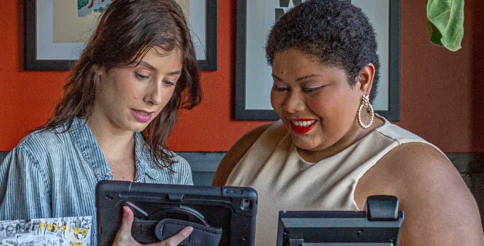 Postino employees working on an iPad.