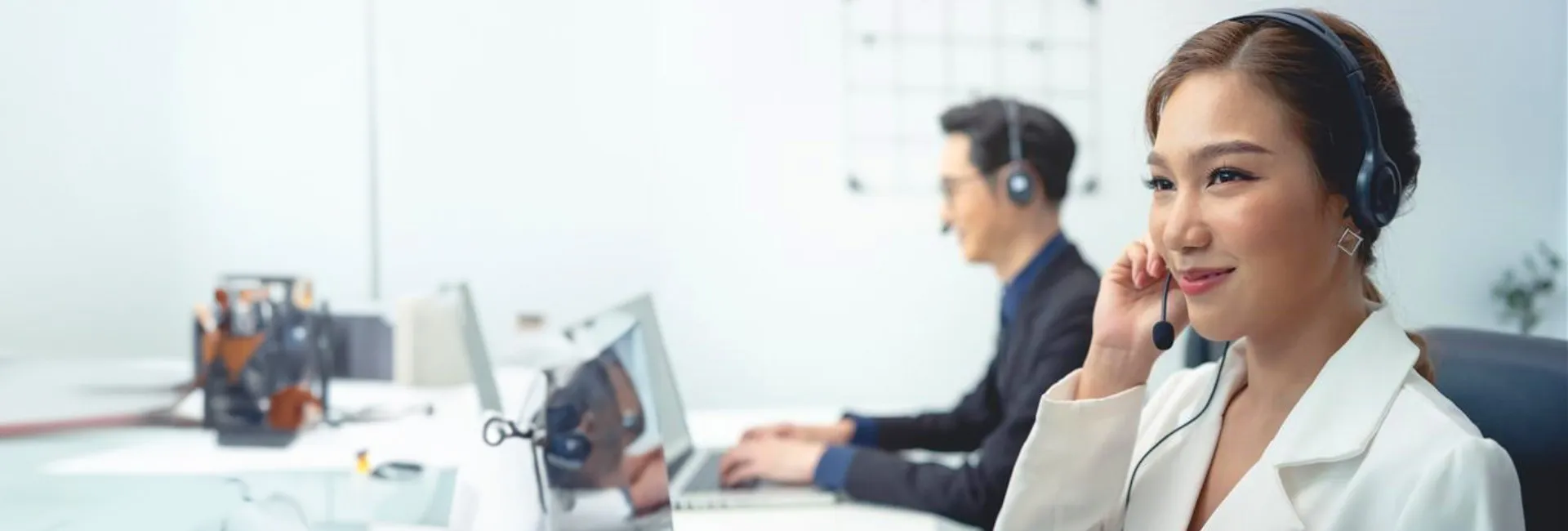 A woman smiling as she makes a call from a headset.