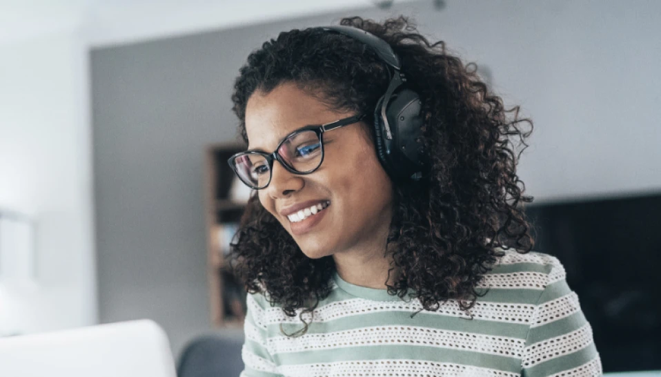 A woman smiling with headphones on.