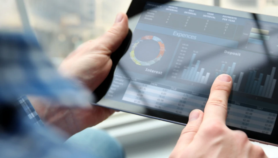 A person using a tablet to review data charts.