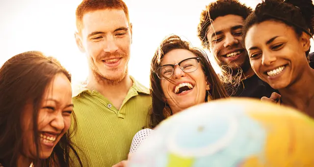 A group of people smiling outside in the sun.