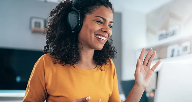 A woman wearing headphones and smiling.