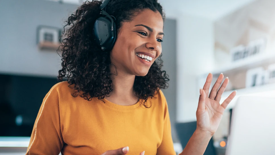 A woman wearing headphones and smiling.