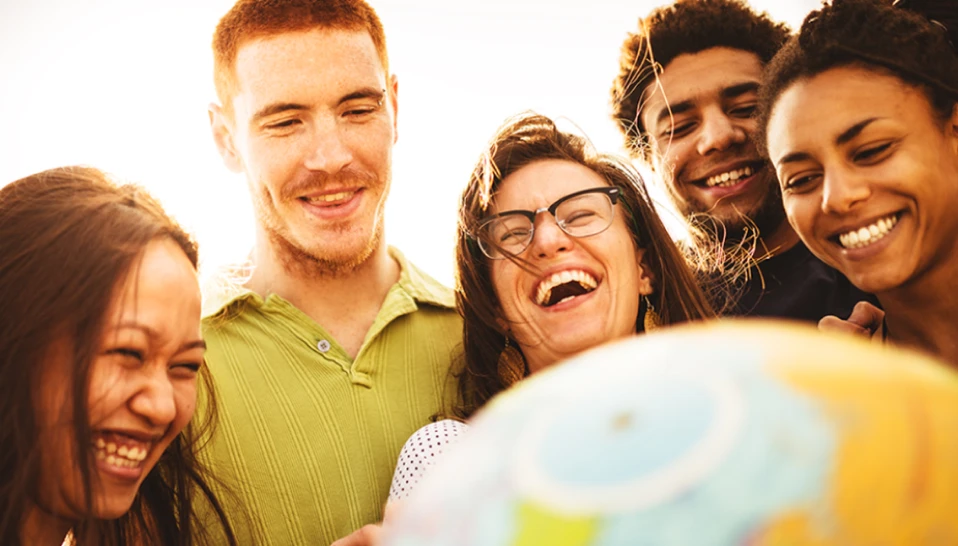 A group of people smiling outside in the sun.
