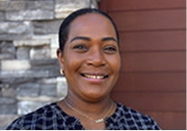 A Red Lobster team member standing outside of a restaurant and smiling.
