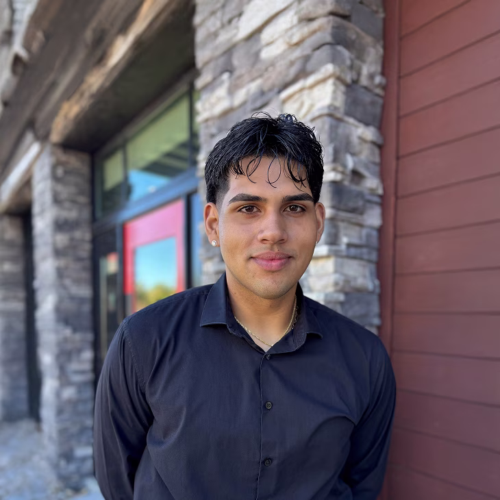 A Red Lobster busser standing outside of a restaurant and smiling.