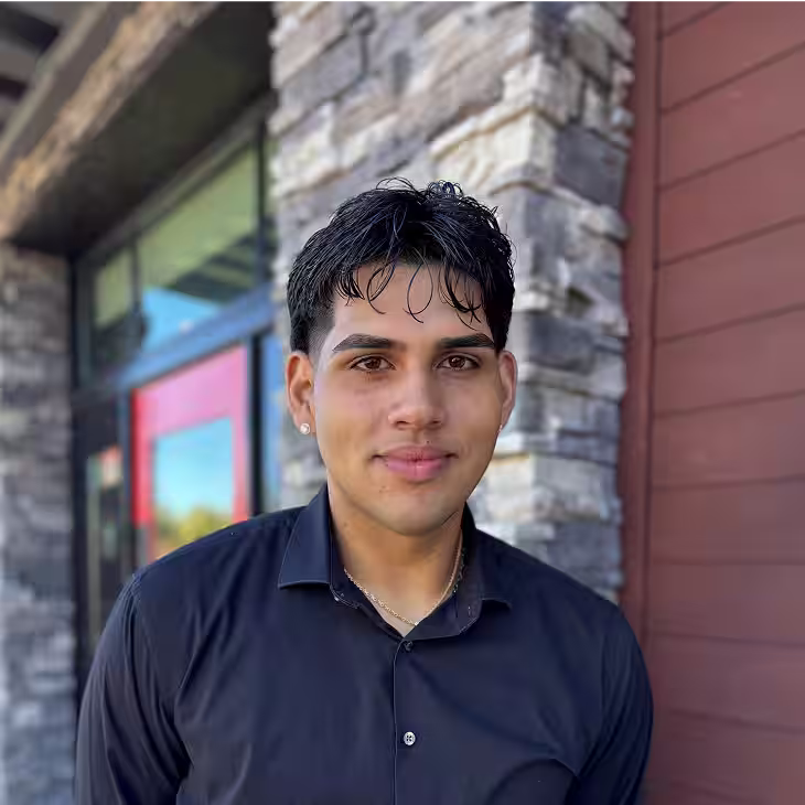 A Red Lobster server assistant standing outside of a restaurant and smiling.