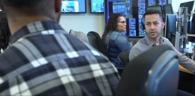 Ross Associates in headsets monitoring information on computer screens