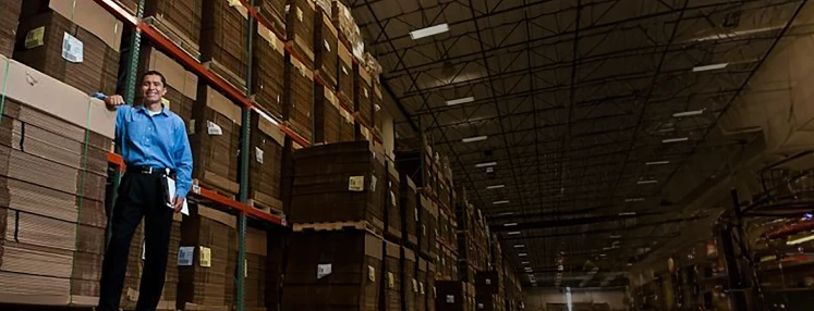 Distribution Associate in Ross warehouse with clipboard