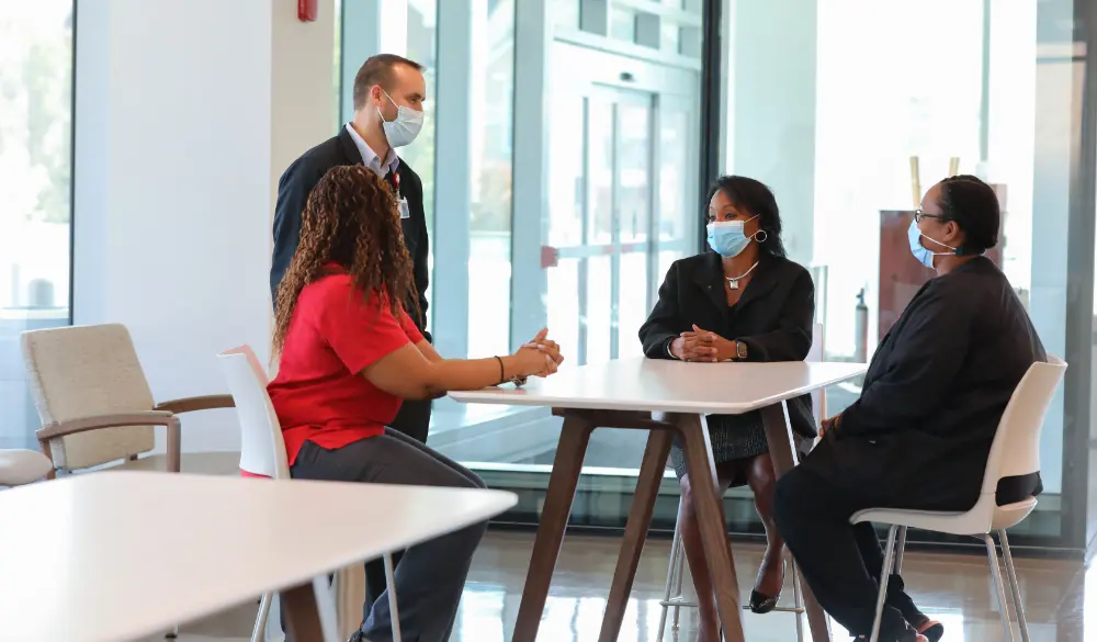 Group of employees sitting and talking with facemask on