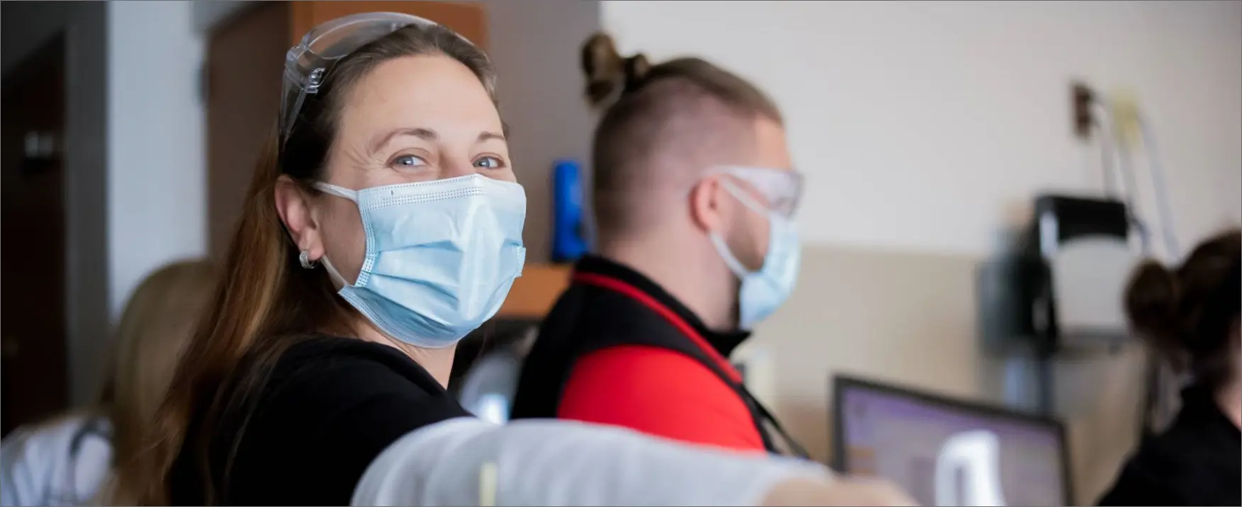 Smiling and welcoming nurse with facemask