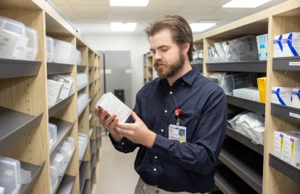 A UC Health employee retrieving medication from a pharmacy.