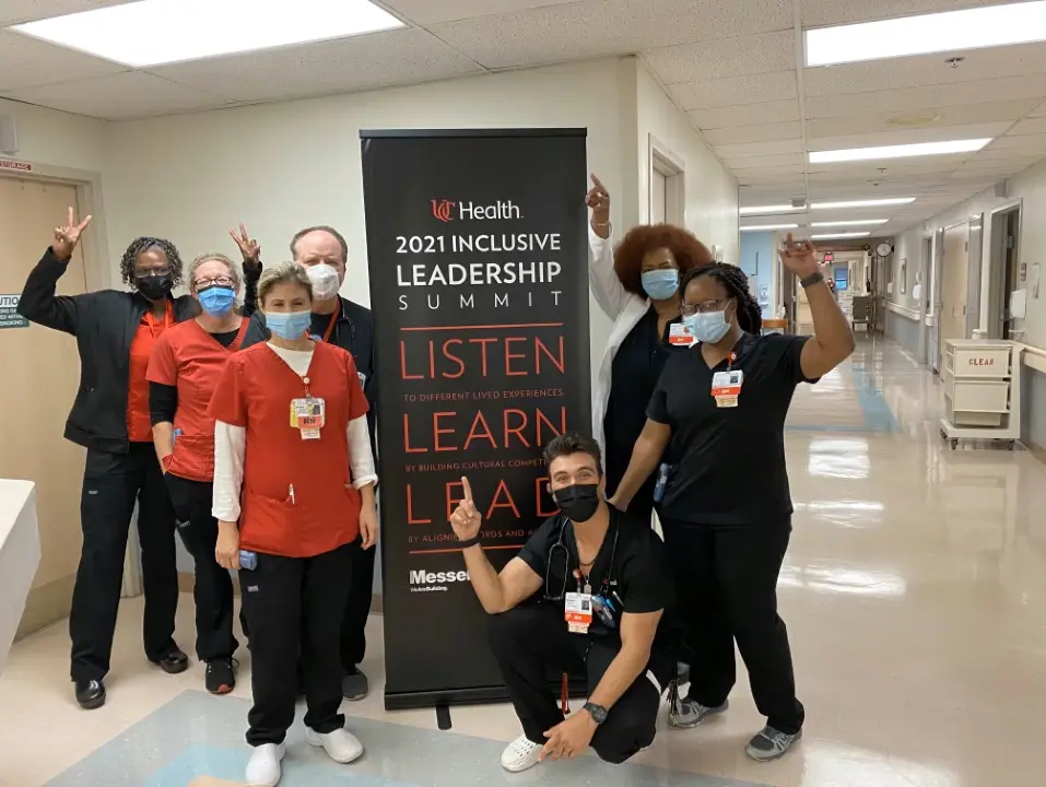 Diverse group of people around 2021 inclusive leadership summit banner